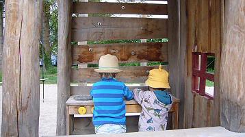 Zwei Kinder spielen in einer Kinderküche